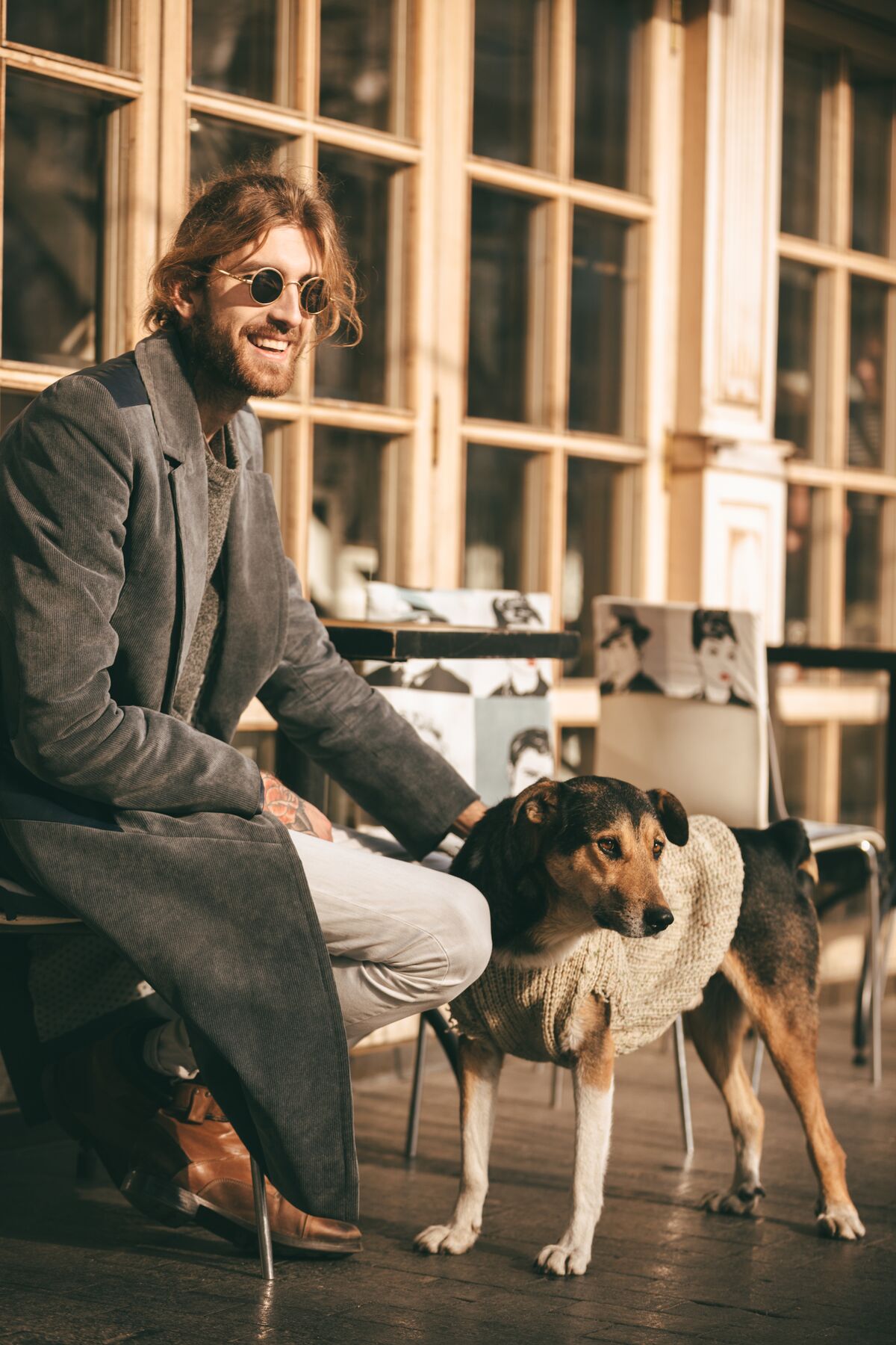A man sharing a sunny café moment with his dog